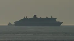 QM2 navigating the anchorage of Rotterdam