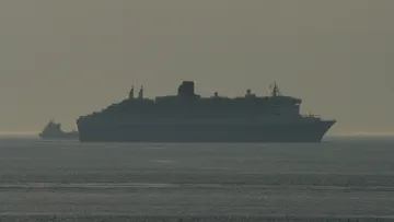 QM2 navigating the anchorage of Rotterdam